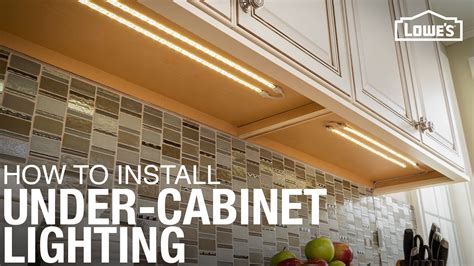 a kitchen with white cabinets and lights above the counter top that is ...