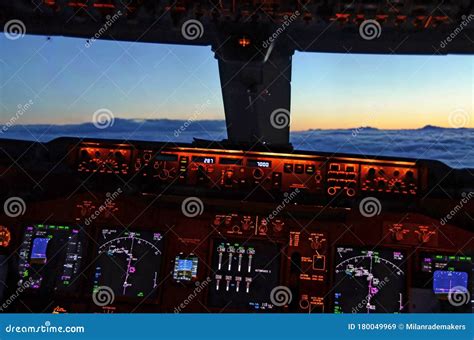 View of the Cockpit of an Airplane with Sunset Flying Above the Clouds ...