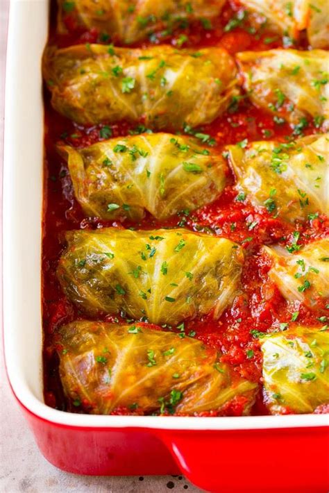 Stuffed cabbage rolls in a baking dish in a pool of tomato sauce ...