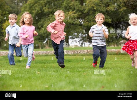 Small group young children running in park Stock Photo - Alamy