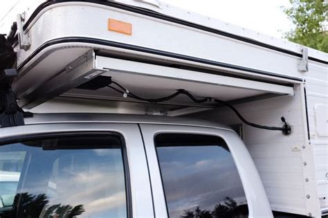 the back end of a white truck with a camper attached to it's roof