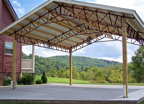 a covered parking lot in front of a red building