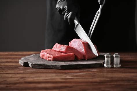 Premium Photo | Butcher cutting pork meat on kitchen