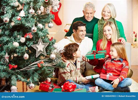 Familia Que Da Los Regalos En La Navidad Imagen de archivo - Imagen de ...