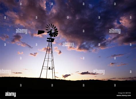 Windmill pump at sunset Stock Photo - Alamy