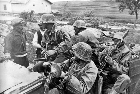 Soldiers of the 5th SS Panzer Division Wiking, in a VW Kübelwagen, talk ...