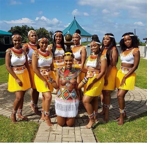 a group of women in yellow dresses standing next to each other on a ...