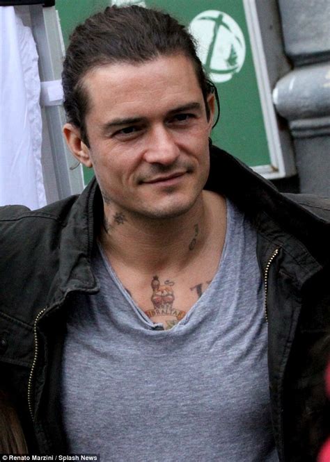 Orlando Bloom ditches his clean-cut look as he shows off neck tattoos ...