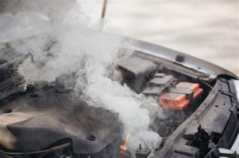 Premium Photo | The engine of the broken car is smoking Closeup