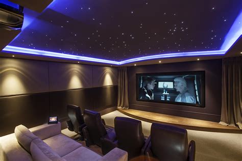 a home theater with two chairs and a large screen on the wall above it ...