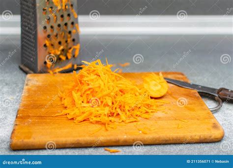 Grated Carrots on a Grater on a Cutting Board Stock Image - Image of ...