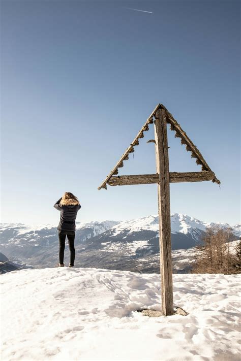 Woman in brown jacket standing on snow covered mountain during daytime ...