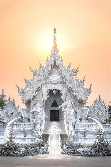 Golden light of sunset fills the sky at the White Temple in Chiang Rai ...