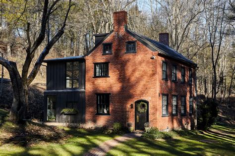 an old brick house surrounded by trees and grass