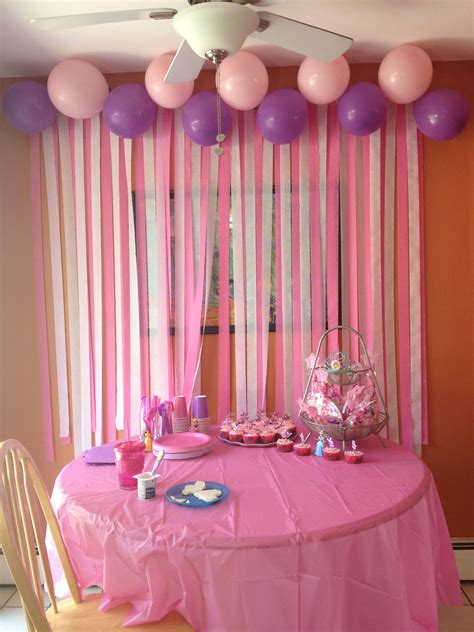 a table with pink and purple balloons on it