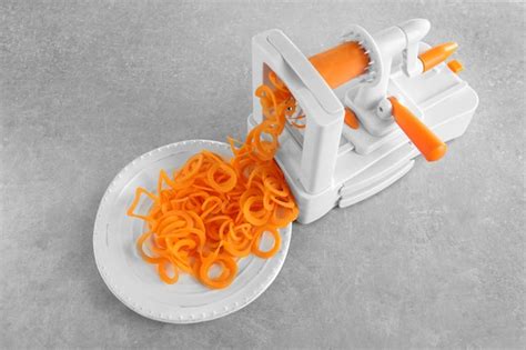 Premium Photo | Spiral vegetable slicer with carrot spaghetti on table