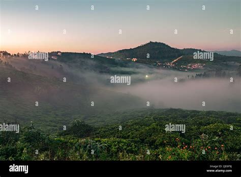 A sunrise view of Ooty hills with mist flowing through the valley Stock ...