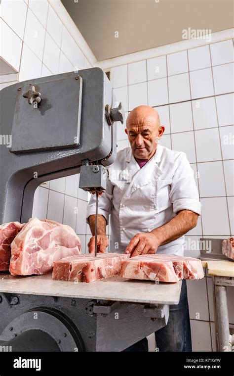 Butcher cutting meat with bandsaw in butchery Stock Photo - Alamy