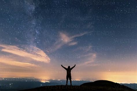 Italy, Monte Nerone, silhouette of a man looking at night sky with ...