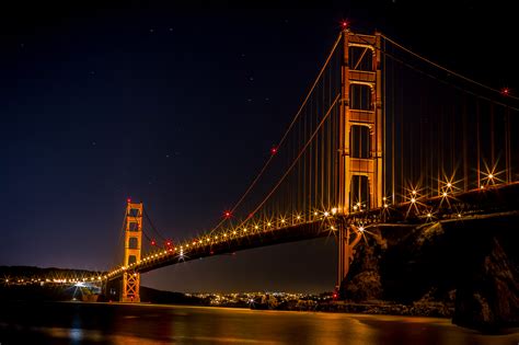 Golden Gate Bridge over the bay at night illuminated in Gold in San ...