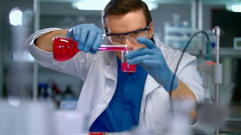 Scientist in lab doing medical research. Laboratory worker pour liquid ...