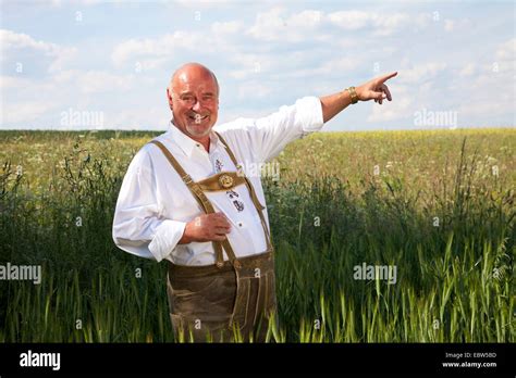 happy old man in traditional german costume standing in grain field and ...