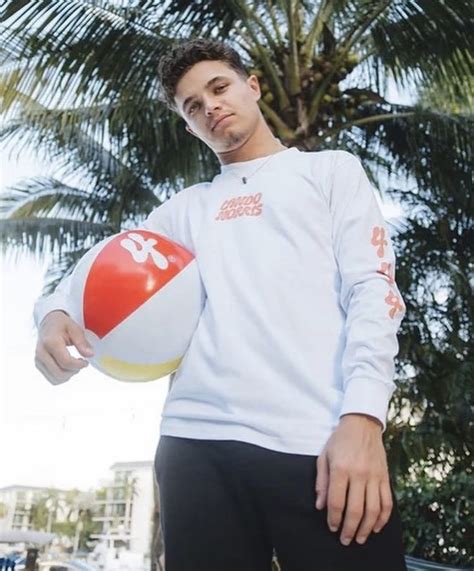 a man holding a beach ball in front of a palm tree with his hands on ...