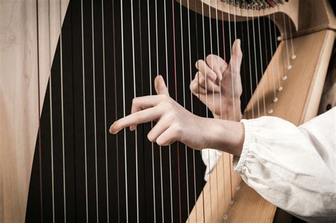 Hands,Playing,Wooden,Harp,On,Black,Background - Orchestra Central