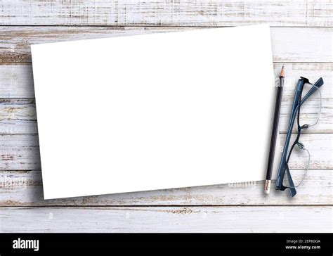 Blank white paper,glasses with pencil on brown wood table background ...