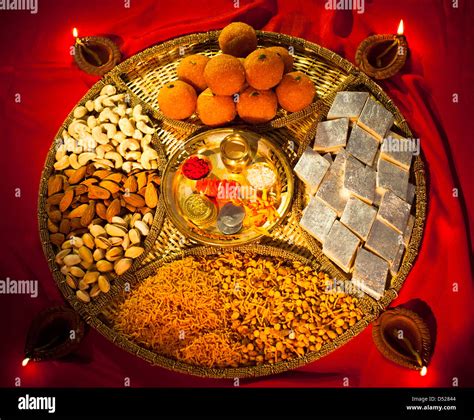 Assorted Diwali sweets and snacks with Diwali diyas Stock Photo - Alamy