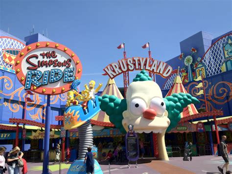 an amusement park with people walking around and clowns on the rides in ...