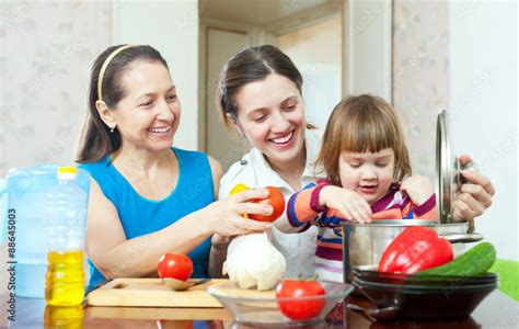 Happy family cooking vegetarian lunch Stock Photo | Adobe Stock