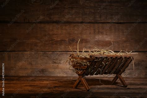 Manger with hay on wooden background Stock Photo | Adobe Stock