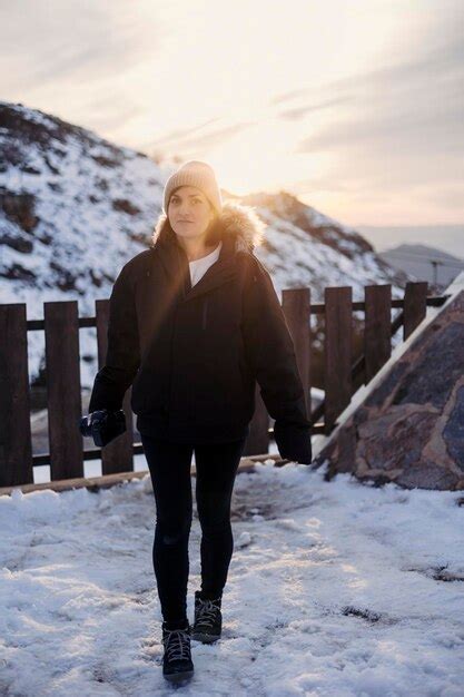 Premium Photo | A woman walks in the snow in front of a mountain