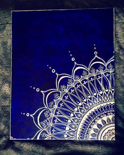 a blue and white painting on top of a black sheet with water drops in it