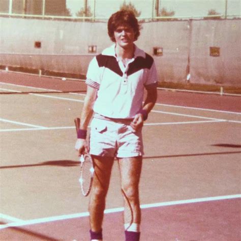 a man standing on top of a tennis court holding a racquet in his hand