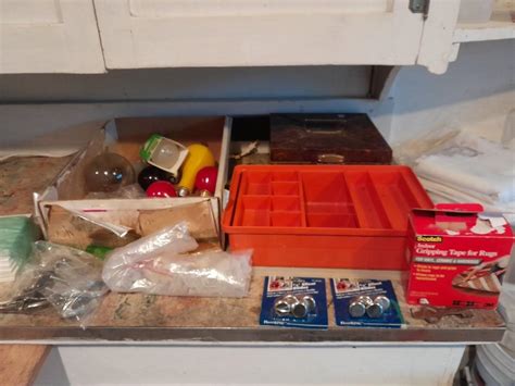 Tupperware organizer with lid, and an assortment of home hardware and ...