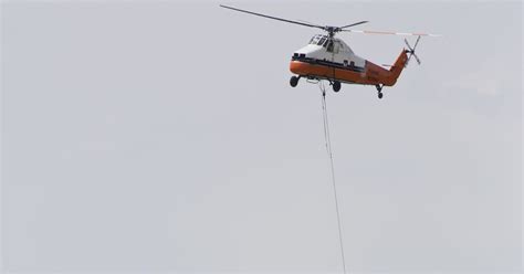 Helicopter hoists HVAC units at construction site