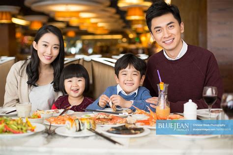 Cheerful young Chinese family having buffet dinner-High-res stock photo ...