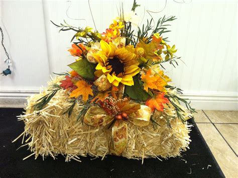 silk flowers nicely arranged on a small hay bale...This would make ...