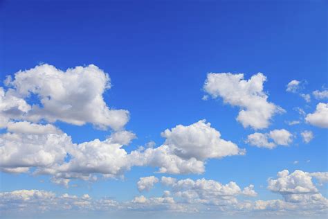 White cumulus summer clouds against a deep blue sky. Photograph by ...