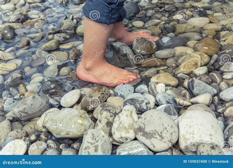 Close Shot of a Person Feet Walking on the Rocks in the Water Stock ...