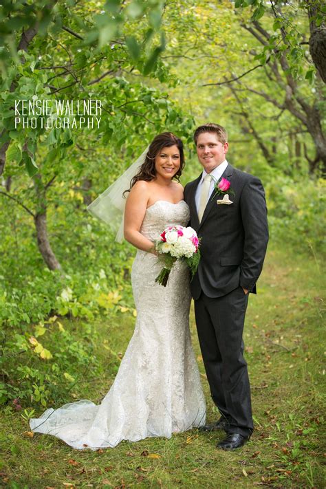 a bride and groom posing for a photo in the woods