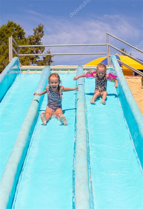 Cute girls on water slide at aquapark during summer holiday — Stock ...