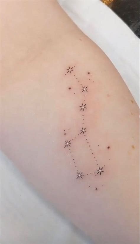 a small star tattoo on the back of a woman's arm