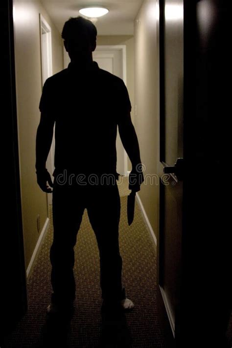 Man With Knife. A mans silhouette is shown coming into a dark room ...