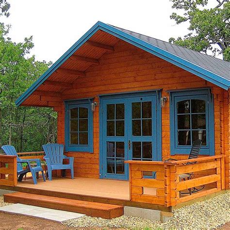 a small wooden cabin with blue doors and two chairs on the front porch ...