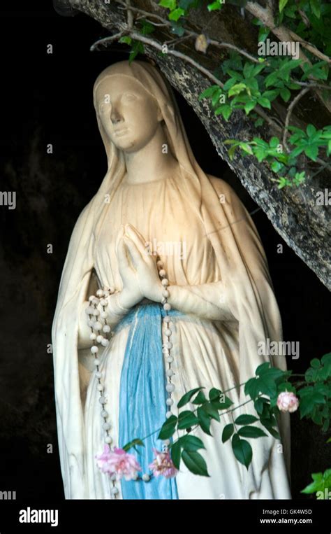 Lourdes, France, France --- Statue of Our Lady of Lourdes in the grotto ...