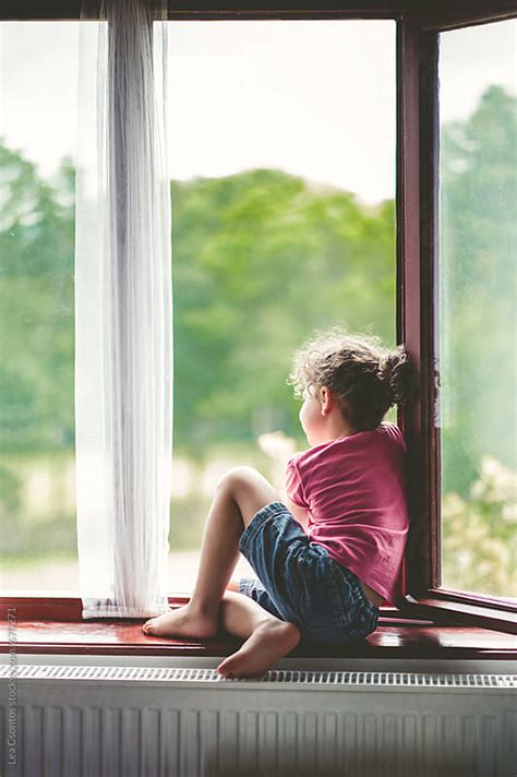 Little girl sitting in a window contemplating by Lea Csontos - Stocksy ...