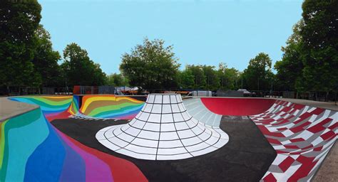 a skateboard park with colorful ramps and trees